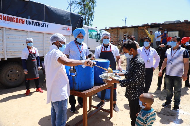 Chandigarh University volunteers give food to poor in nearby villages