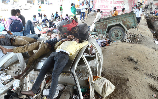 Awaiting nod to board train, migrants camp under flyovers