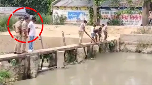 In UP, cops stand and watch kids fish out dead body from canal; suspended: watch video