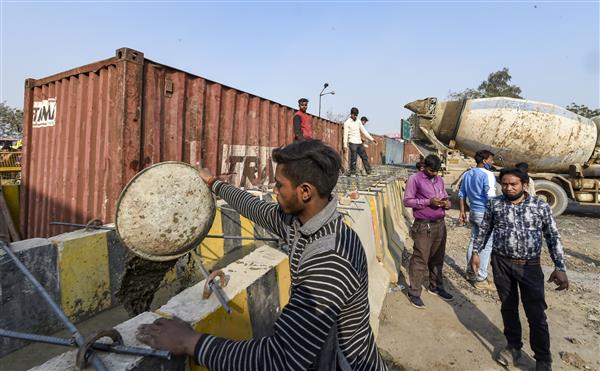 Iron bars hooked between barriers, cement poured in to create makeshift wall at Singhu border
