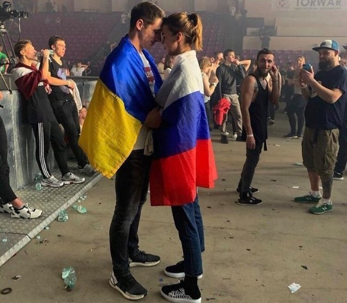 Amid war an old photo of man draped in Ukrainian flag hugging woman in Russian flag trends again