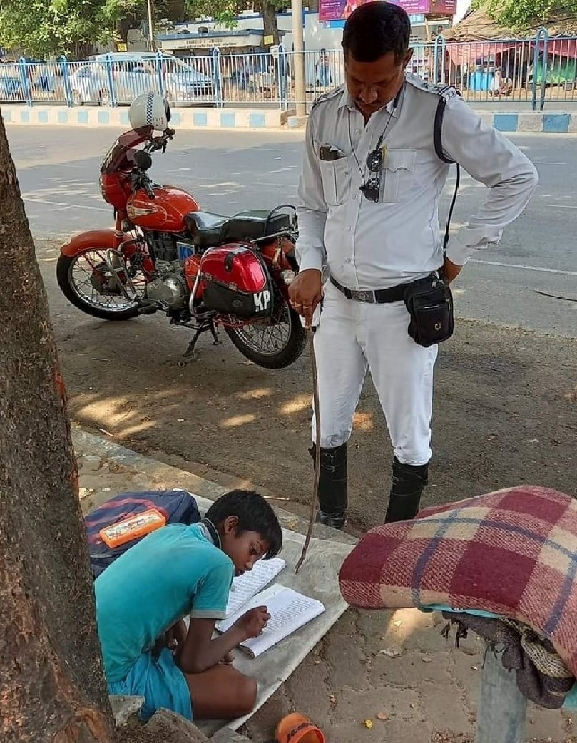 Kolkata cop wins hearts after his picture of teaching a child while managing traffic goes viral