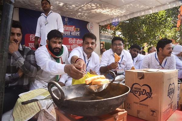Congress workers hold 'Degree Holder Shoes Polish, Pakoda stall' outside protest rally venue in Delhi