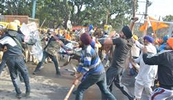 Attacked by protesters with spears, cops run for cover