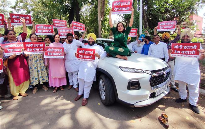 Chandigarh AAP stages protest, puts up anti-Modi posters on cars