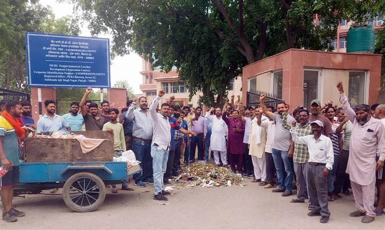 Protesting sanitation staff dump garbage outside GMADA office in Mohali
